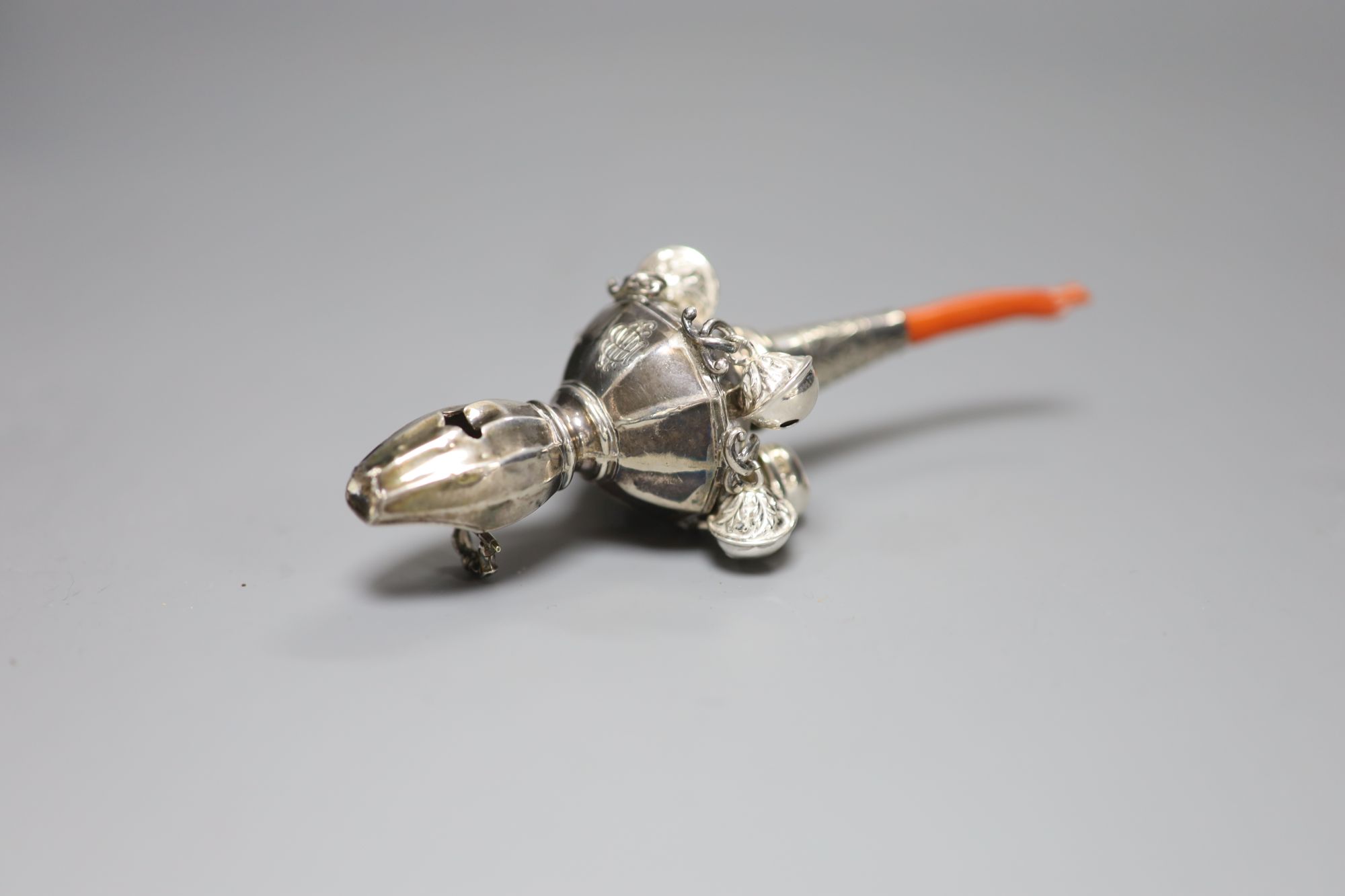 A George V silver childs rattle with coral teether and six bells, Crisford & Norris, Birmingham, 1911, 13cm.